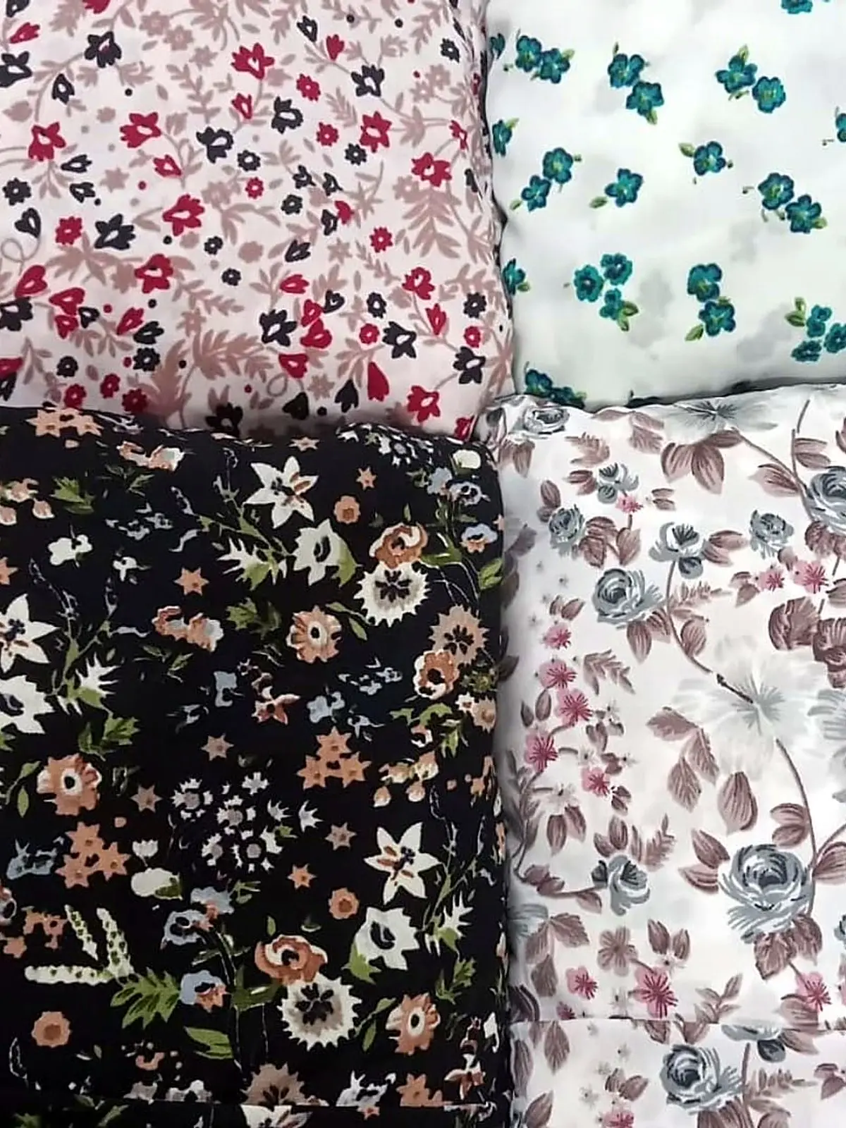 Folded floral cotton lawn fabrics in pink, white, black and grey prints