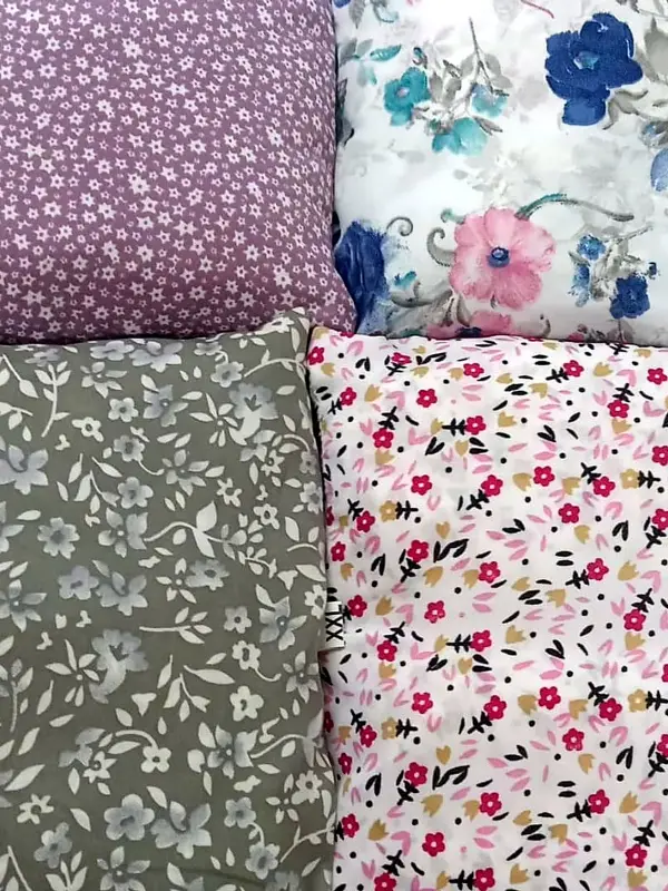 Four folded cotton salwar materials in lilac, white, grey and pink florals