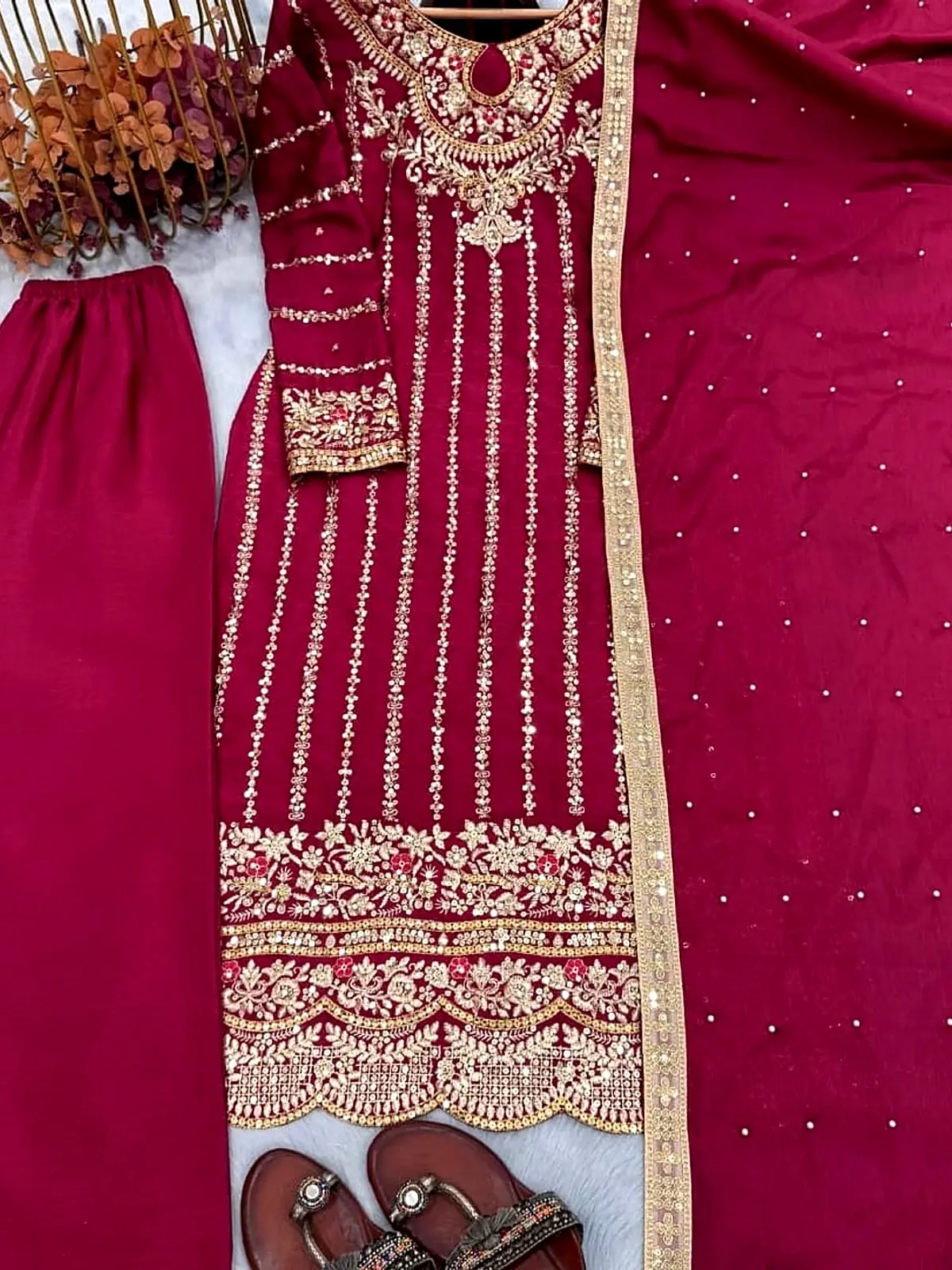 Magenta kurta with gold zari stripes, trousers and dupatta, laid flat